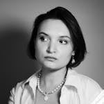 Black and white portrait of a woman reading, deep in thought.
