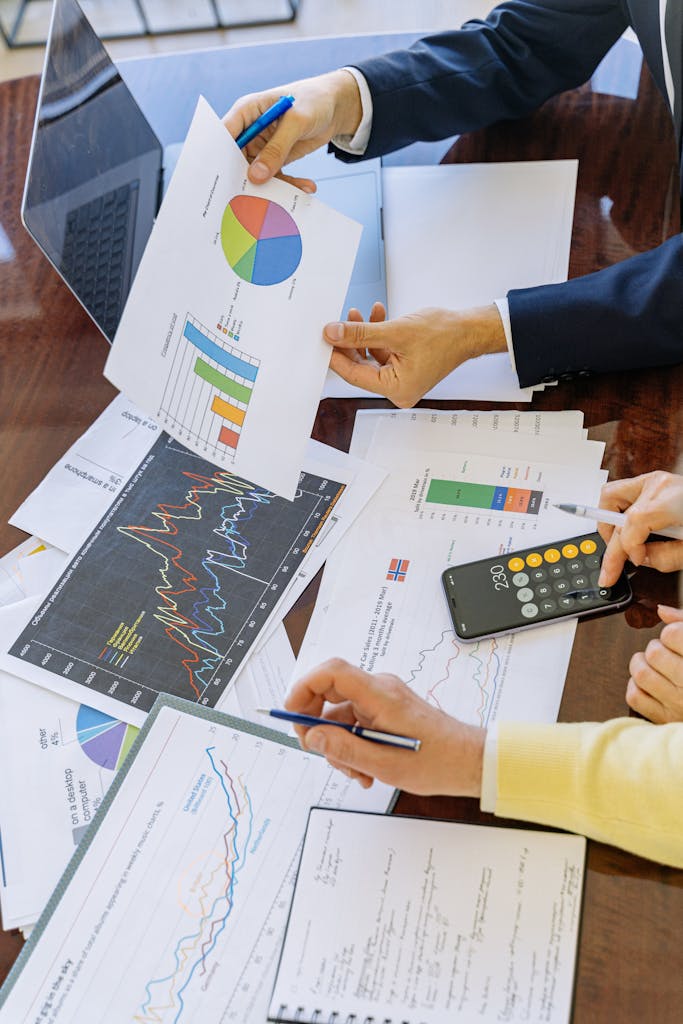 Business professionals analyzing Insurance charts and graphs during a meeting.