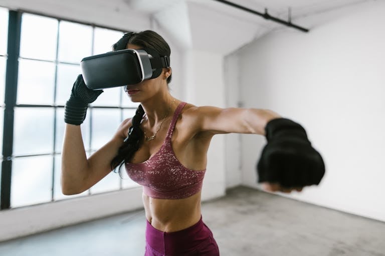 A fit woman wearing a VR headset exercises with boxing punches indoors, connecting technology and fitness.
