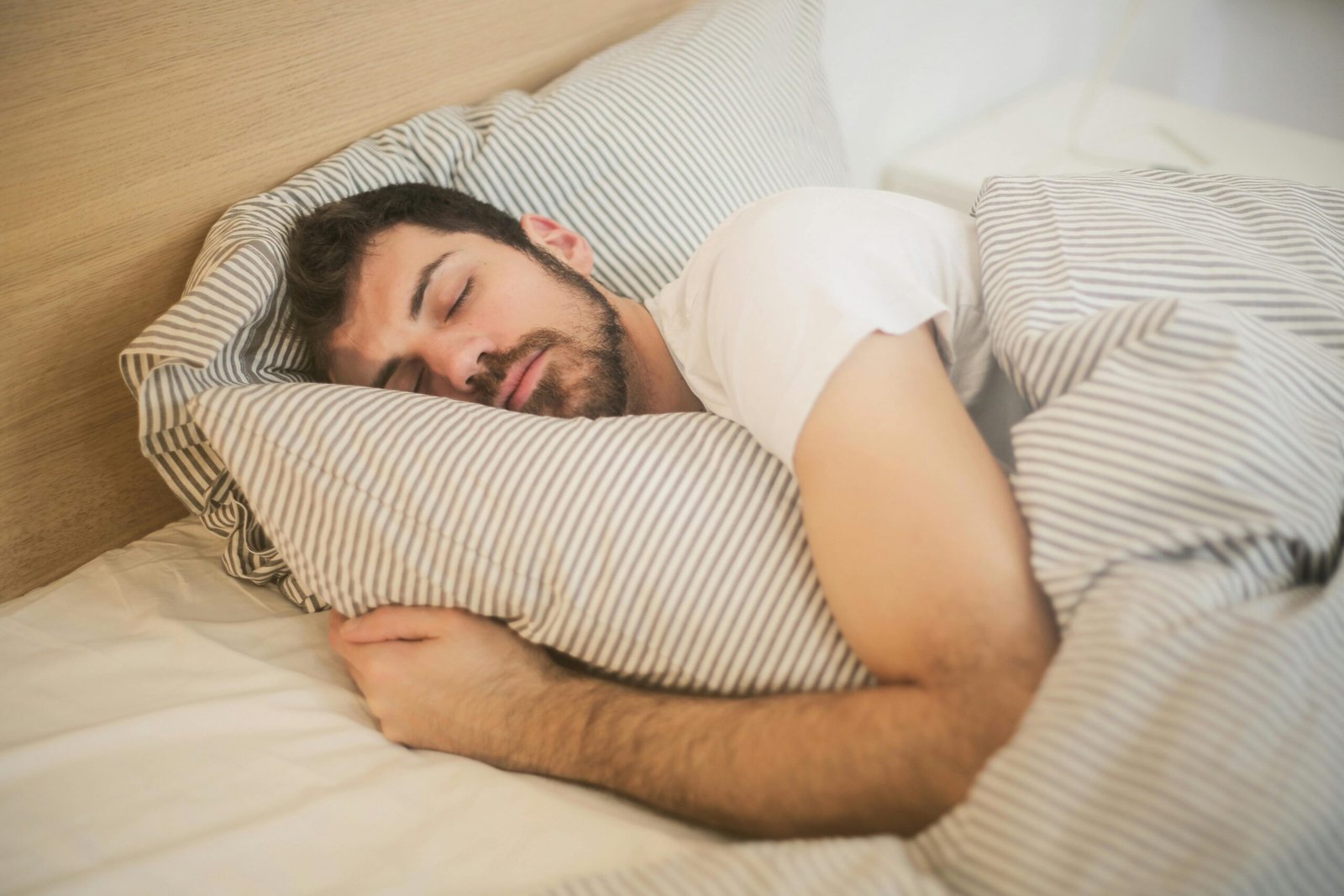 man sleeping peacefully in bed showing natural deep sleep and body recovery