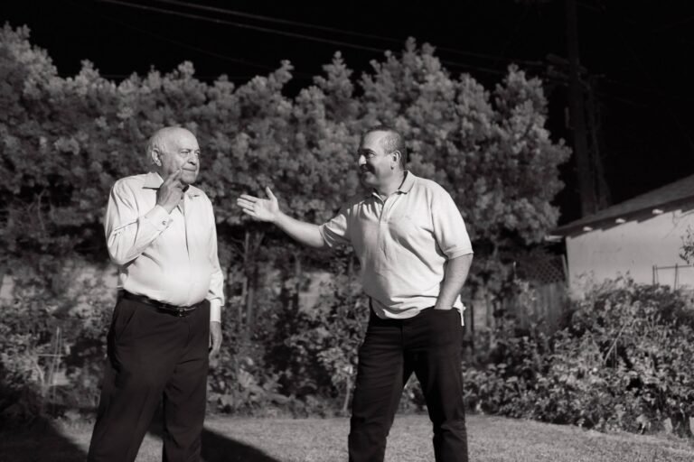 Older father and adult son talking outdoors, a reminder that heart risk runs in families